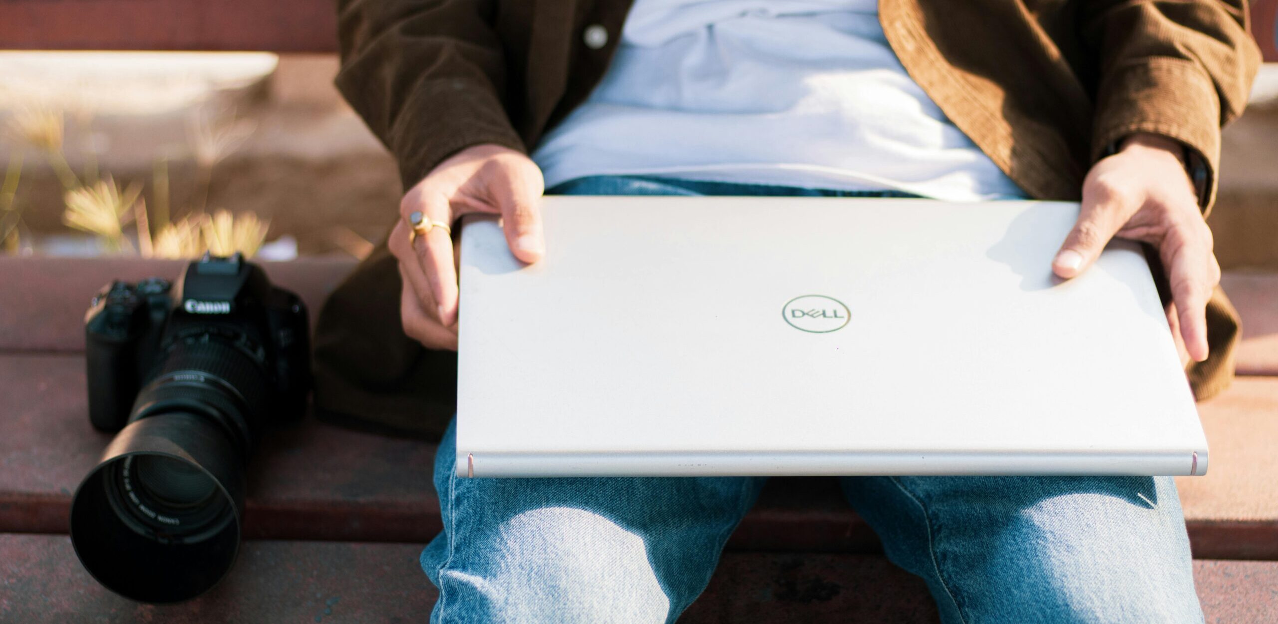 A man holding a Dell laptop on his lap